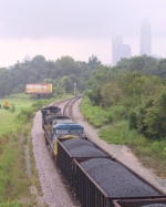 CSX 741 & 98 sit in the siding with a loaded coal train near the downtown skyline